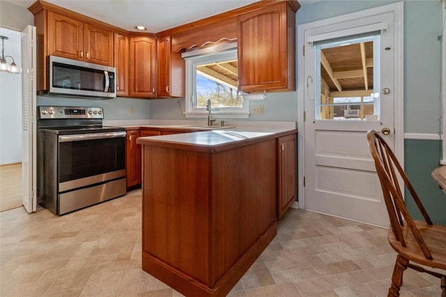 kitchen with appliances with stainless steel finishes, kitchen peninsula, and sink