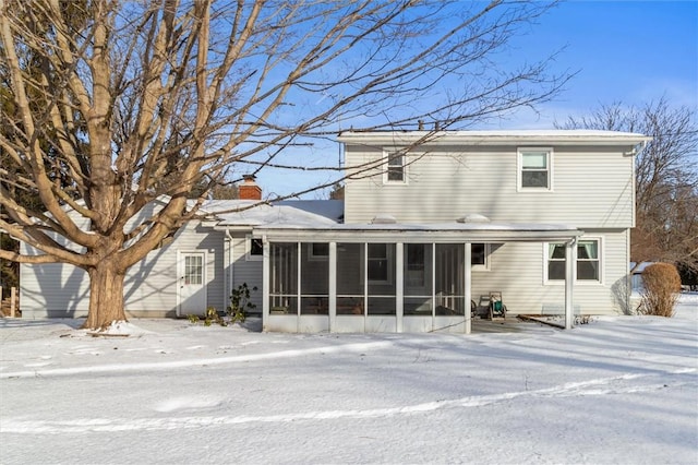 snow covered house with a sunroom