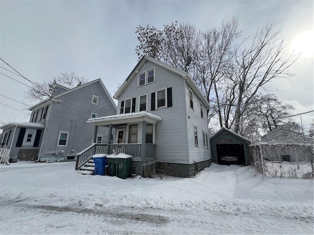 snow covered back of property with a porch