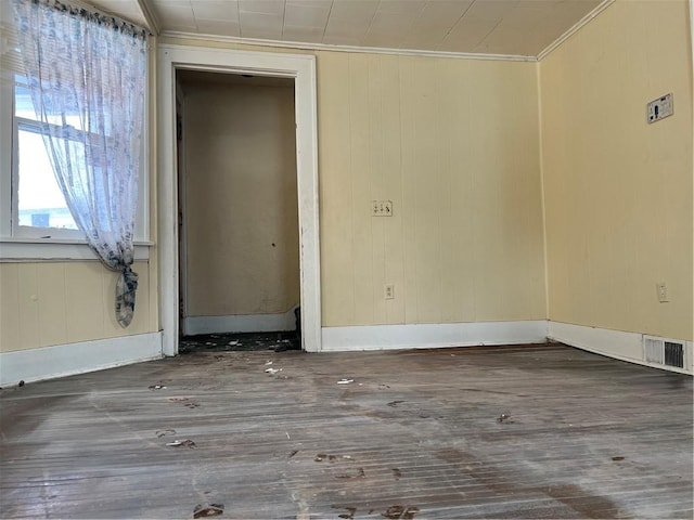 empty room featuring ornamental molding and dark hardwood / wood-style floors