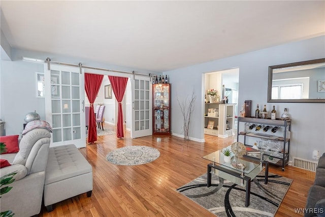 living room featuring wood-type flooring and a barn door