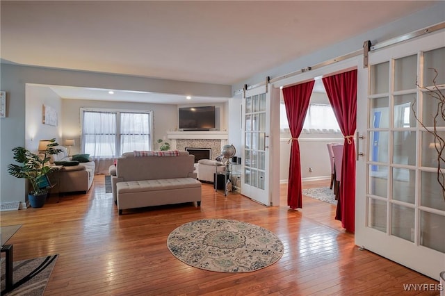 living room featuring a barn door, hardwood / wood-style floors, and french doors