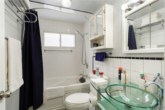 full bathroom featuring sink, tile walls, shower / tub combo with curtain, and toilet