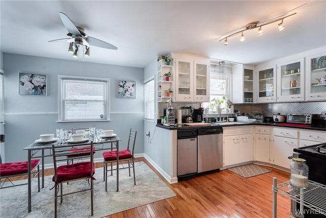 kitchen with dishwasher, sink, white cabinets, decorative backsplash, and light hardwood / wood-style flooring