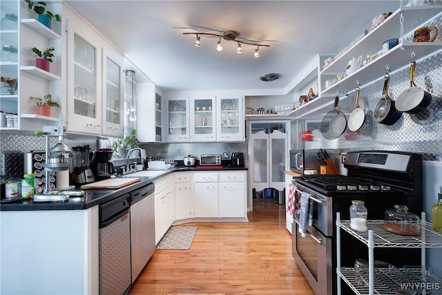 kitchen featuring sink, stainless steel appliances, white cabinets, decorative backsplash, and light wood-type flooring