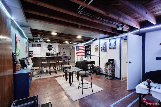 basement featuring bar area and white refrigerator