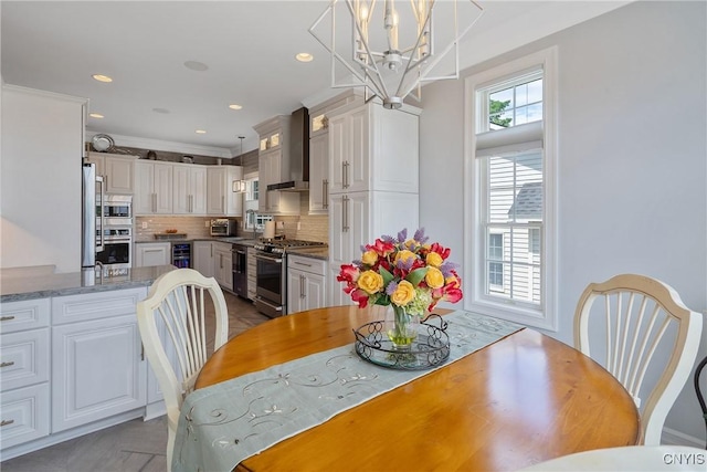 dining area featuring ornamental molding, light parquet floors, beverage cooler, and a notable chandelier