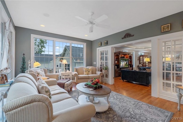 living room with light wood-type flooring and ceiling fan