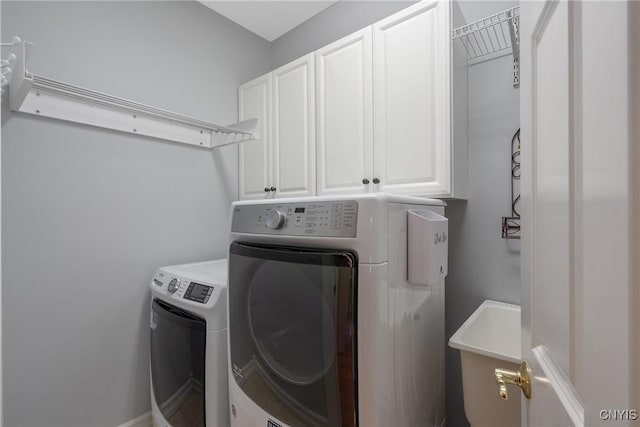 laundry area featuring sink, washer and dryer, and cabinets