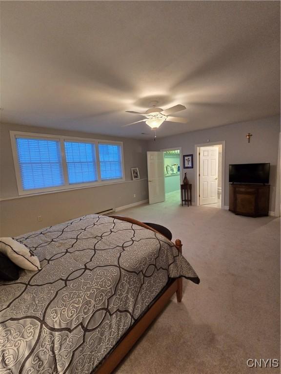 carpeted bedroom featuring ceiling fan and baseboard heating