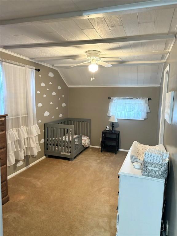 carpeted bedroom featuring a crib, lofted ceiling, and ceiling fan