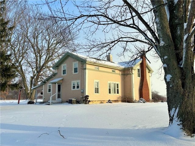 snow covered property with central AC unit