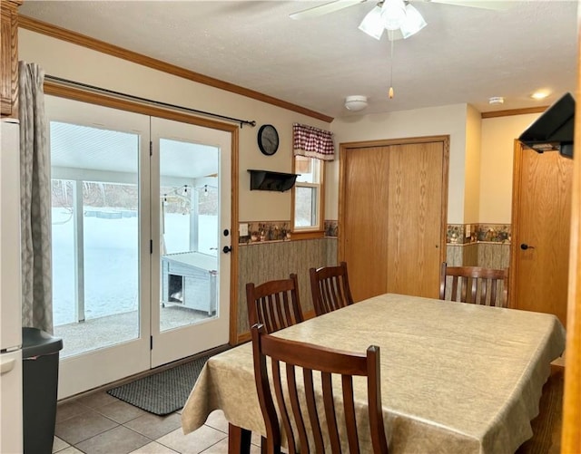 tiled dining area with crown molding and ceiling fan