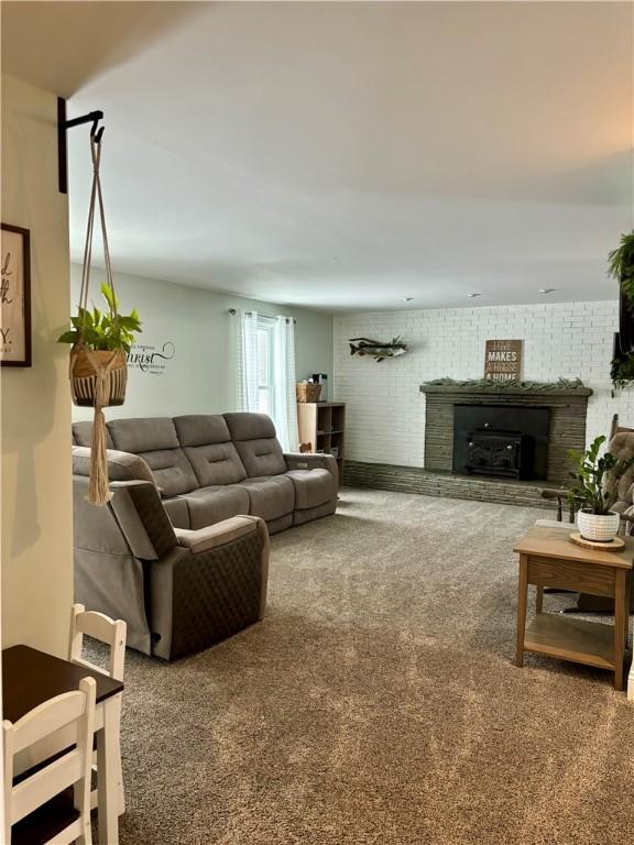 carpeted living room featuring brick wall and a fireplace