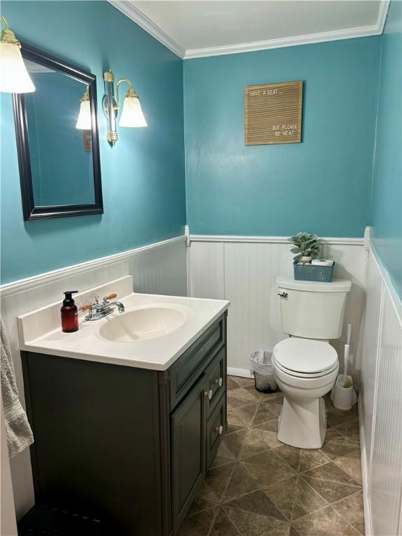 bathroom featuring vanity, ornamental molding, and toilet