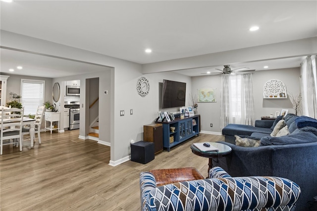 living room featuring wood-type flooring and ceiling fan