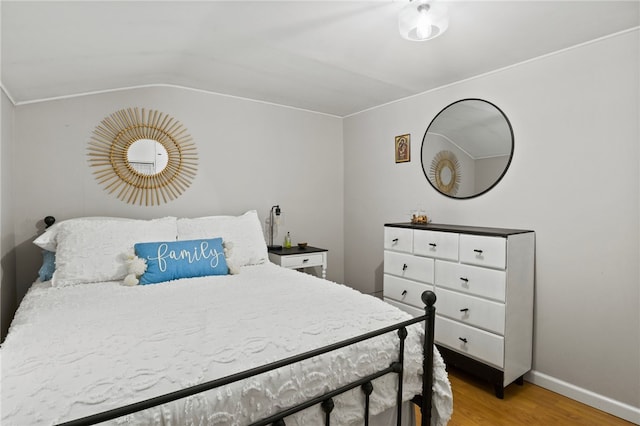 bedroom featuring vaulted ceiling and hardwood / wood-style floors