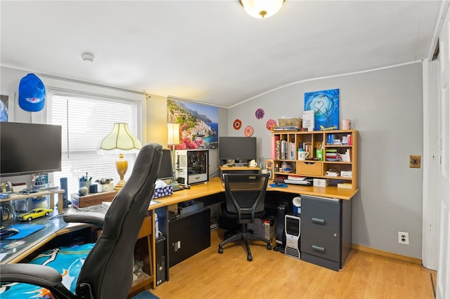 home office with lofted ceiling and light hardwood / wood-style floors