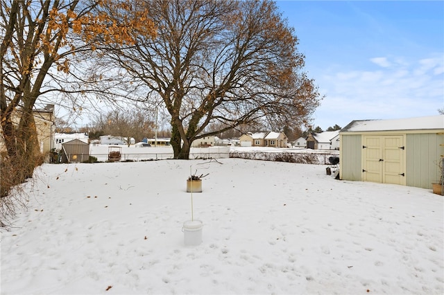 snowy yard with a shed