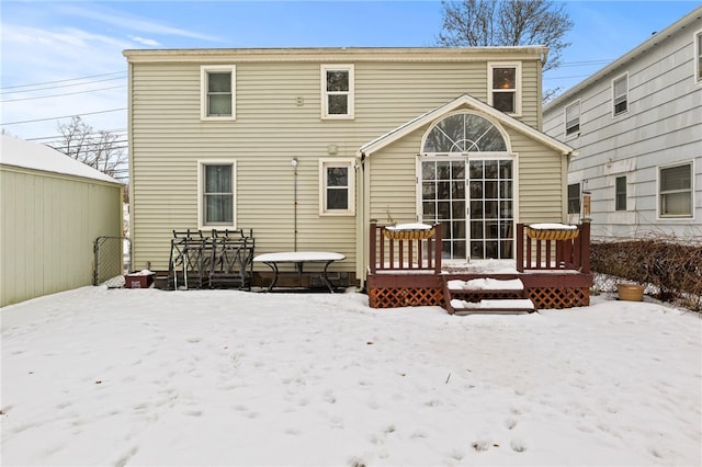 snow covered house with a wooden deck