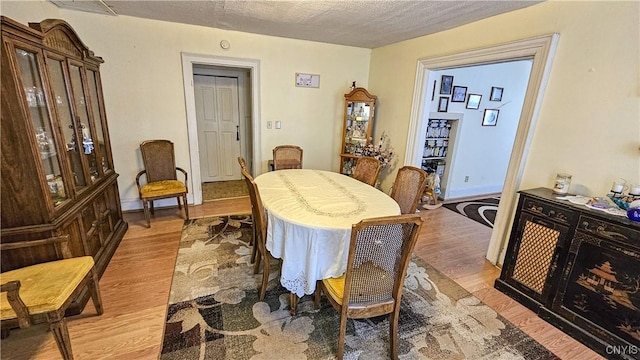 dining room featuring a textured ceiling and light wood-type flooring