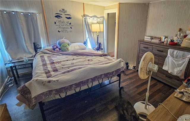 bedroom with dark hardwood / wood-style floors and wood walls