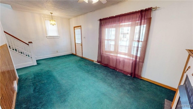 interior space with dark colored carpet, a textured ceiling, and ceiling fan