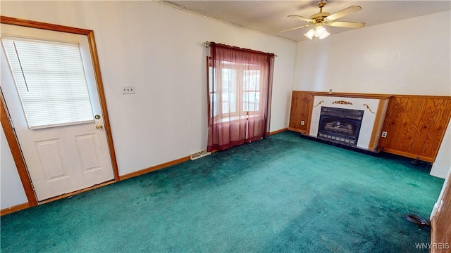 unfurnished living room with dark colored carpet and ceiling fan