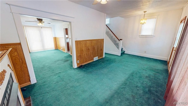 interior space with dark carpet, plenty of natural light, and ceiling fan