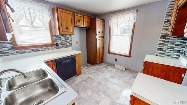 kitchen featuring tasteful backsplash, dishwasher, and sink