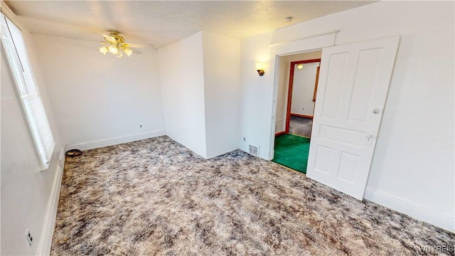 carpeted spare room featuring ceiling fan