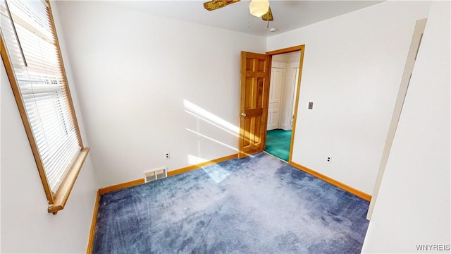 carpeted empty room featuring ceiling fan