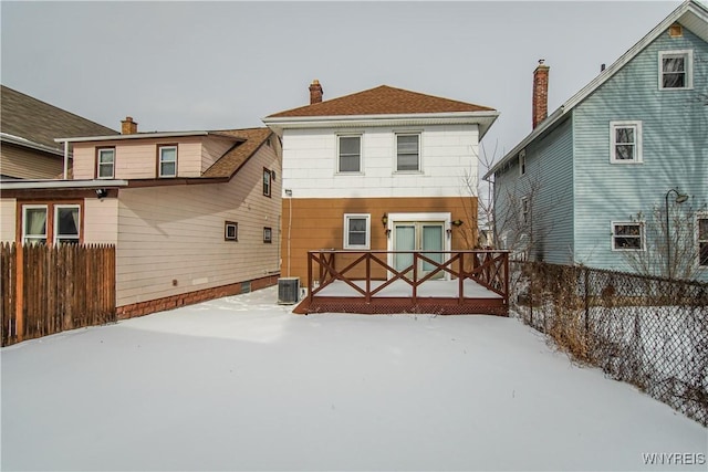 snow covered back of property featuring a deck and central air condition unit