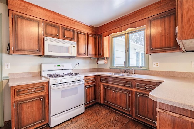 kitchen with dark hardwood / wood-style flooring, sink, and white appliances