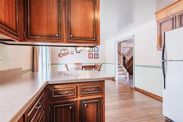 kitchen featuring hardwood / wood-style flooring and white fridge