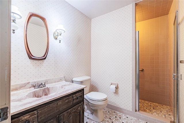 bathroom featuring a tile shower, vanity, tile patterned floors, and toilet