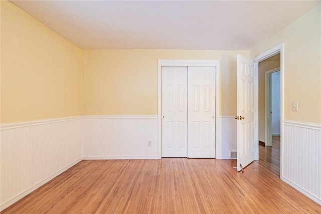 unfurnished bedroom with a closet and light wood-type flooring