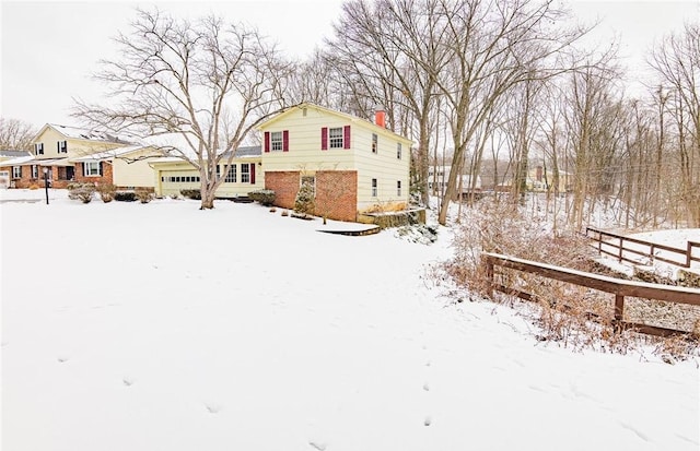 yard layered in snow featuring a garage