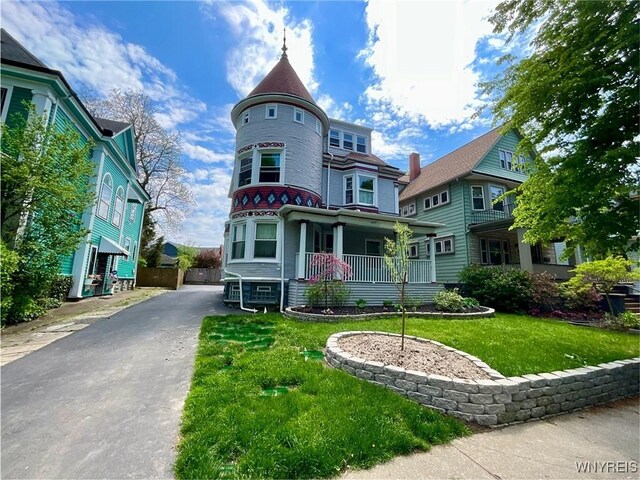 victorian home with covered porch and a front lawn