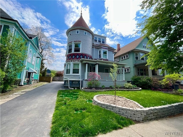 victorian home with a front yard and a porch