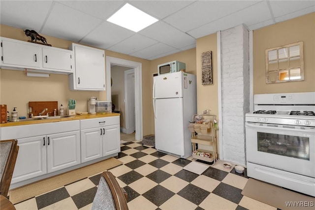 547 Potomac Ave, Buffalo, NY 14222 - kitchen with white cabinetry, white appliances, a paneled ceiling, and sink