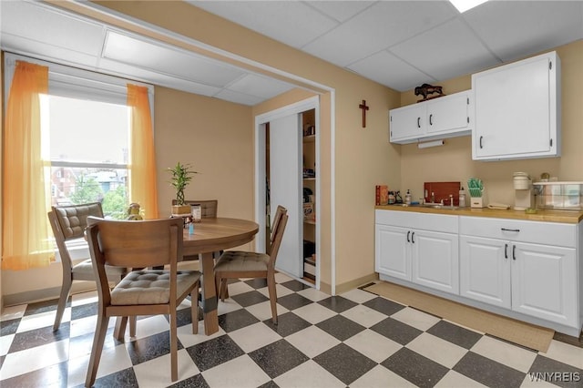 547 Potomac Ave, Buffalo, NY 14222 - kitchen with white cabinetry, sink, and a drop ceiling