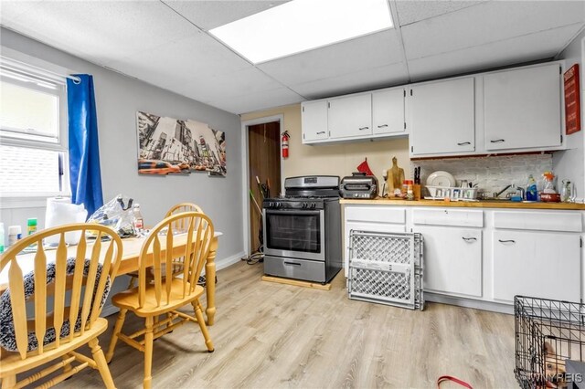 547 Potomac Ave, Buffalo, NY 14222 - kitchen with white cabinetry, a paneled ceiling, stainless steel range with gas stovetop, and light hardwood / wood-style flooring