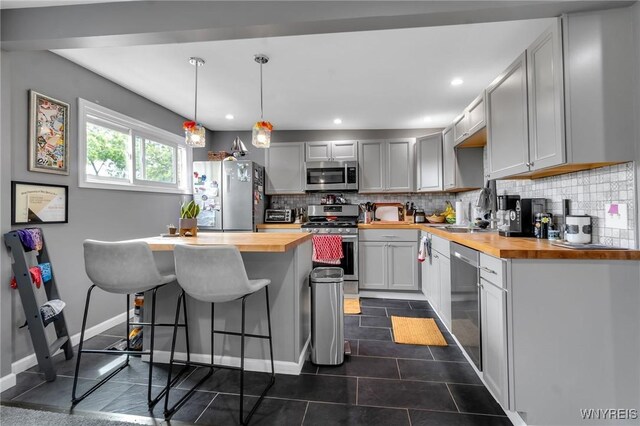 547 Potomac Ave, Buffalo, NY 14222 - kitchen featuring pendant lighting, sink, appliances with stainless steel finishes, wood counters, and decorative backsplash