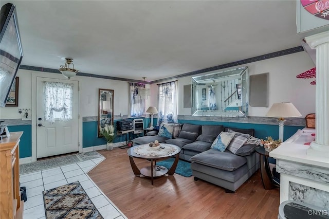 living room featuring ornate columns, ornamental molding, plenty of natural light, and light wood-type flooring