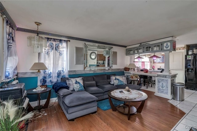 living room with crown molding, hardwood / wood-style floors, and a notable chandelier