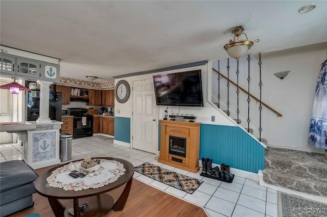 living room featuring ornate columns and light tile patterned flooring