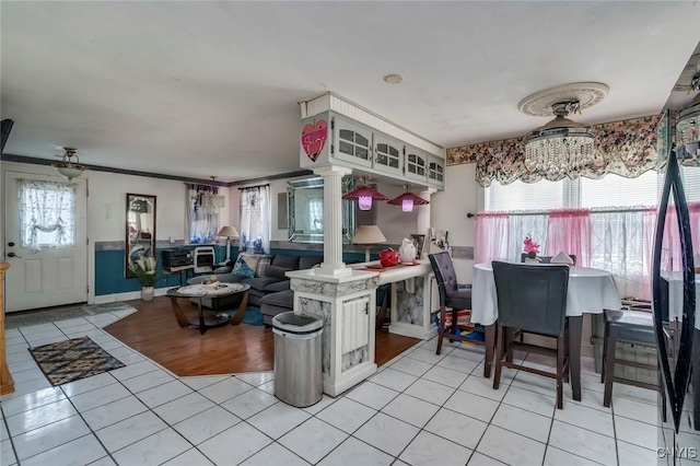 kitchen featuring light tile patterned floors, a notable chandelier, plenty of natural light, and kitchen peninsula