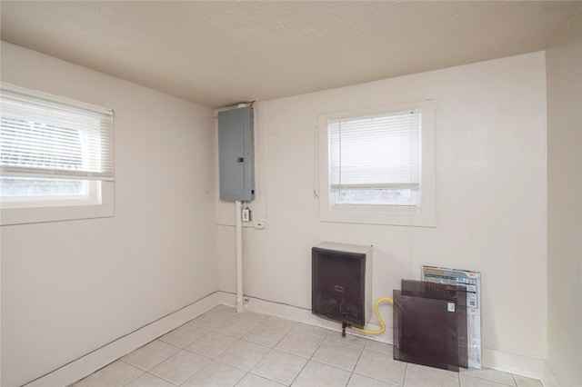 empty room featuring light tile patterned floors, electric panel, and a textured ceiling