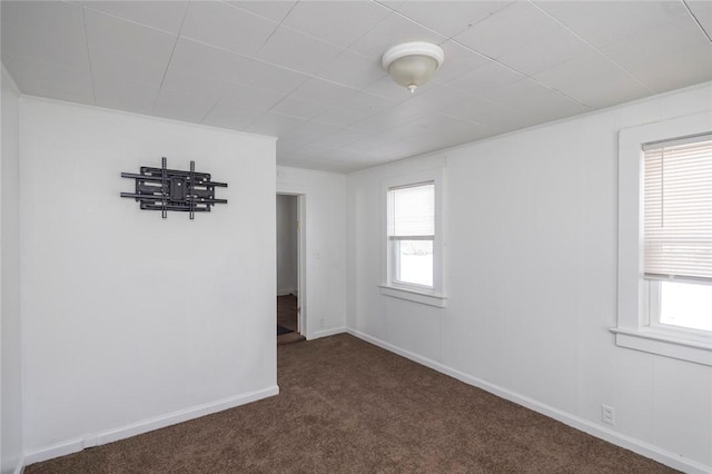 spare room with a healthy amount of sunlight and dark carpet